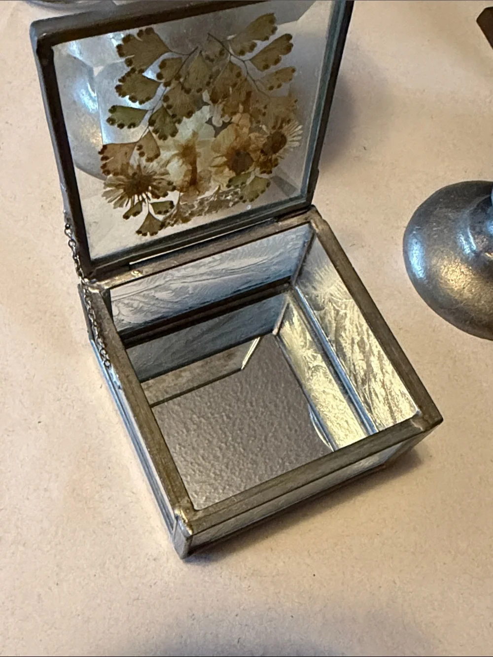 Vintage trinket box with metal edges and dried flowers on top. Mirror bottom.